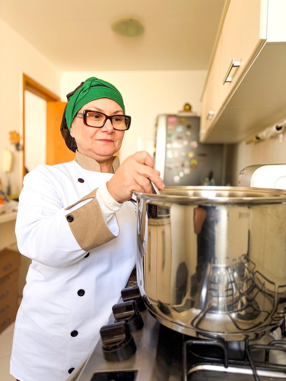 Jacqueline, da Origens Artesanais, preparando geleia em panela grande na cozinha